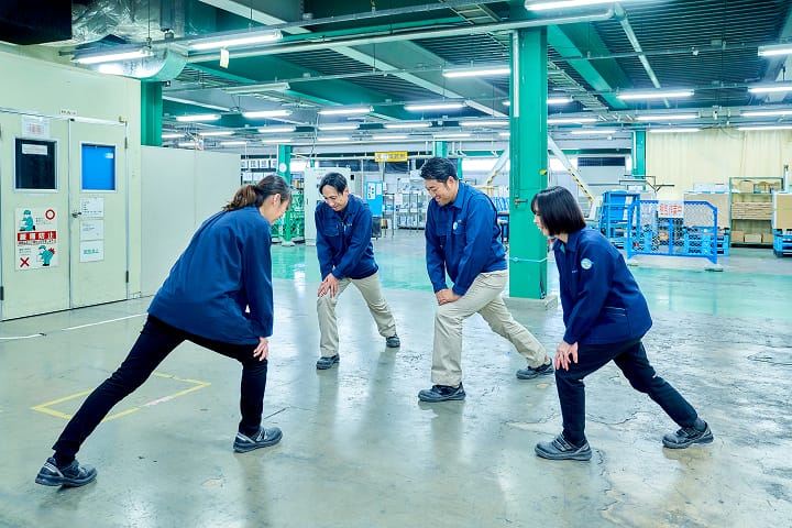 向かい合ってストレッチをしている従業員4名